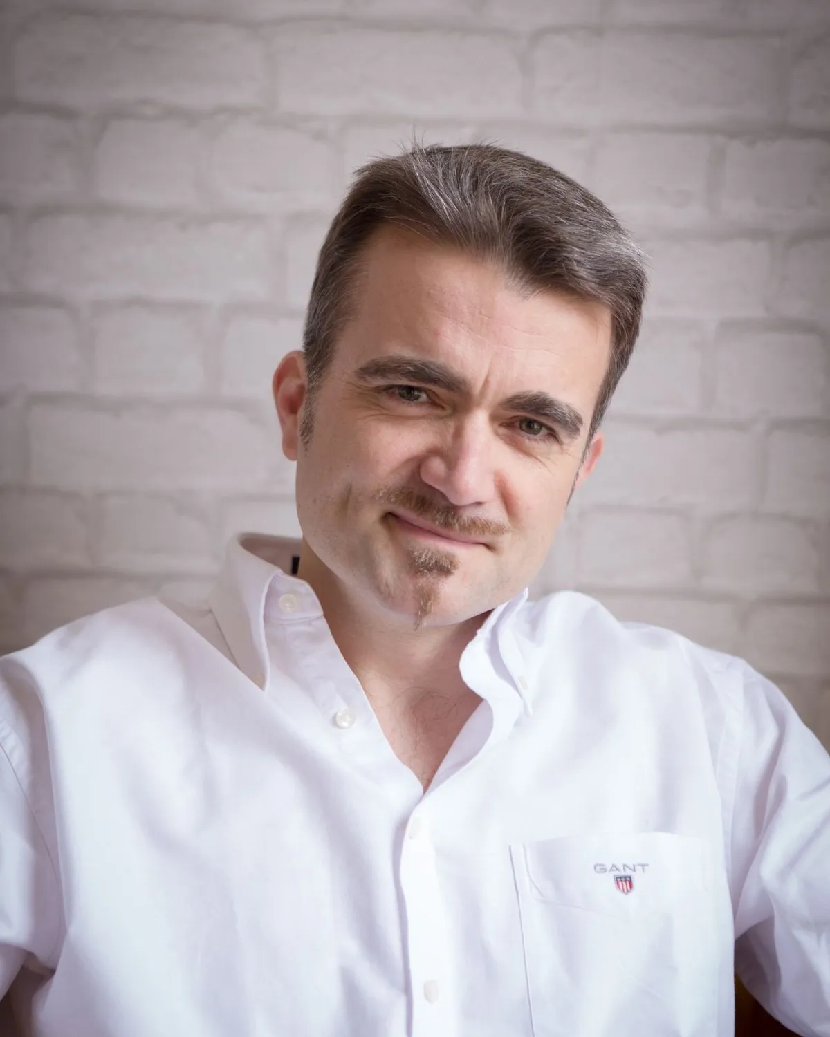 Olivier Collet, ostéopathe, en chemise blanche, souriant